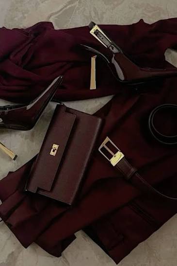 Accessoires bordeaux disposés sur un tissu